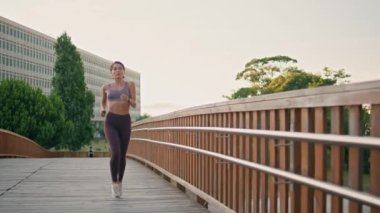 Sabah köprüsünde koşan motive bir sporcu. Kaslı, fit bir kadın spor kıyafetleriyle kardiyo antrenmanı yapıyor. Esmer profesyonel koşucu, park alanında kısa mesafe koşusu yapıyor. Dayanıklılık kavramı