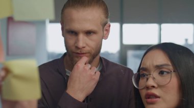 Çıkartma duvarındaki portreye katılmayan kızgın kız. Gergin iş arkadaşları hippi ofisindeki şeffaf kargaşada tartışıyorlar. Hüsrana uğramış iş kadını toplantı odasında meslektaşıyla yüzleşiyor. 