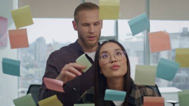 Odaklanmış takım arkadaşları ofiste çıkartmaları yakın planda tartışıyor. Ciddi geliştiriciler şeffaf kurulun yanında beyin fırtınası yapıyorlar. Kuşkucu serbest çalışanlar panoramik pencereler dairesindeki iş akışını birlikte yönetiyorlar 