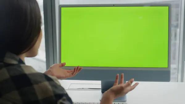 Startuper videocalling greenscreen computer at office closeup. Unknown woman explaining video call using mockup device. Unrecognizable freelancer gesturing chromakey monitor at panoramic windows flat