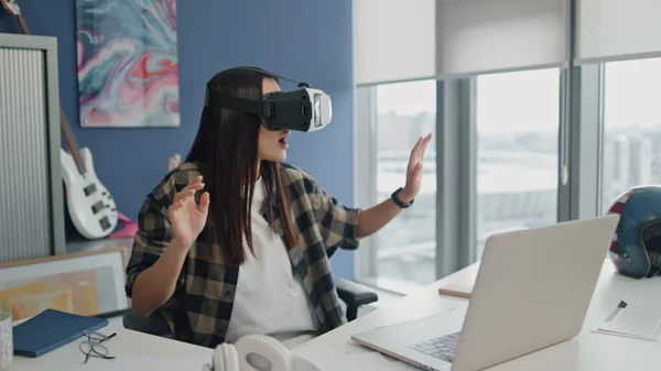 Amazed girl exploring 3d space at office closeup. Excited online streamer trying new virtual cyberspace game at blue wall room. Vr glasses woman enjoying modern gadget at panoramic windows flat