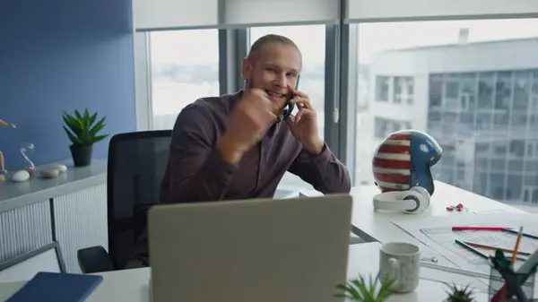 Emotional specialist discussing phone call at home closeup. Positive man giving consultation support by phone call at remote office. Millennial guy holding telephone talking colleague at windows room