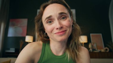 Neşeli iş kadını, ev görüntülerinde görüntülü konuşma yapıyor. Çevrimiçi sohbet eden mutlu arkadaş canlısı kız, yakın planda haberlere tepki veriyor. Gülümseyen kadın iş arkadaşını arıyor yalnız başına web kamerasına bakıyor. 