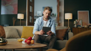 Düşünceli adam tablet masasını eve koyuyor. Düşünen adam çözümü tek başına düşünüyor. Aklı karışmış serbest çalışan akşam oturma odasında koltukta oturuyor gibi görünüyor. Halk yaşam tarzı konsepti