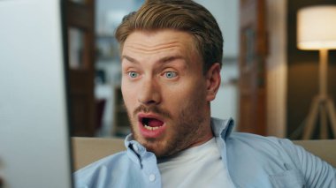 Merak eden adam kapalı mekanda tablet okurken şaşırdı. Şaşırtıcı adam yüz ifadesini evde yapan bir bilgisayardan izledi. Yakışıklı iş adamı elinde dijital cihazla beklenmedik haberler alıyor.