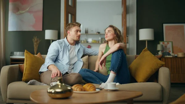 Calm family talking sofa at living room. Relaxed boyfriend girlfriend chilling couch discussing life routine together. Serious woman telling story handsome man at apartment interior. People lifestyle