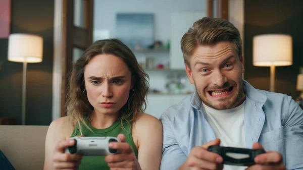 Gamers pair competing console game in pov view. Excited cheering man winner looking at loosing wife celebrating victory closeup. Upset woman feeling embarrassed staring aside. Hipster couple playing