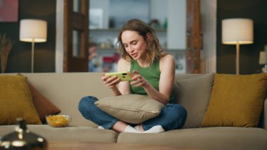Duygusal hipster akşam apartmanında akıllı telefon oyunu oynuyor. Heyecanlı bir kadın internetteki cep telefonu aktivitelerinden zevk alıyor. İnteraktif roket stratejisi yayınlayan mutlu oyuncular. Eğlence konsepti