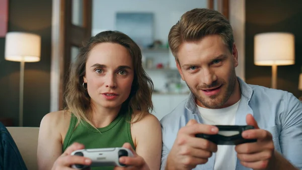 Funny partners winning game holding joypads indoor pov. Emotional gamers playing videogame closeup. Excited carefree friends chilling at evening. Pair using modern tech. Digital entertainment concept