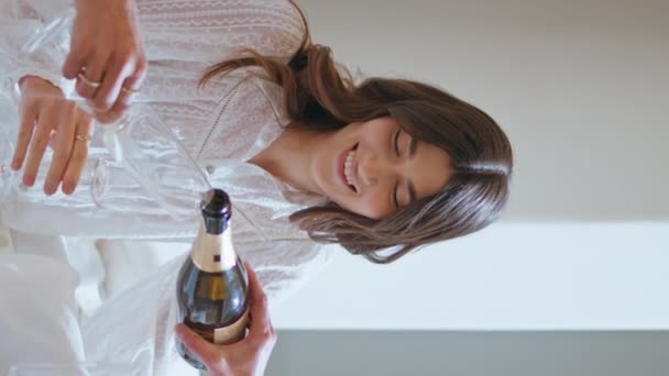 ホームパーティーのクローズアップにシャンパンを注ぐ女性の友人 ブライダルシャワーをお祝いするエキサイティングな女の子は 垂直ショットで一緒に休暇を楽しんでいます ワイングラスを保持する魅力的な女性モデル休憩スパルーム — ストック動画