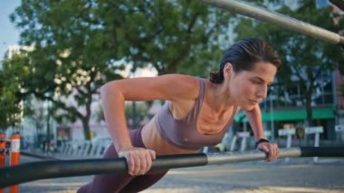 Spor yapan kadın sporcu spor salonundaki egzersizleri yakından takip ediyor. Spor eğitmeni spor salonunda fonksiyonel antrenman yapıyor. Güçlü vücut geliştiren kadın yatay çubuk kullanıyor. 
