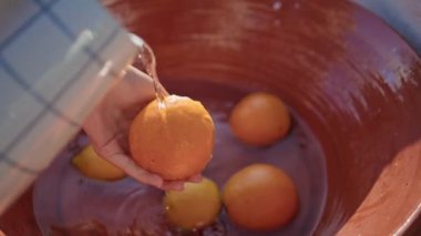 Kasede narenciye temizleyen kız elleri. Sadece yaz balkonunda meyvelere su döken anonim bir kadın. Tanınmayan bir kadın portakal yıkıyor. Doğa köyünde öğle yemeği hazırlıyor.