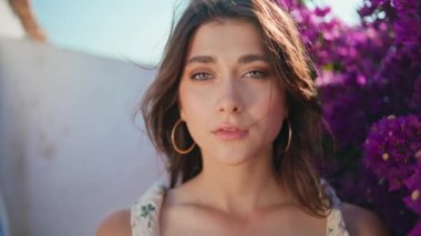 Portre şehvetli kadın mor çiçekleri narin elbiseler içinde poz veriyor. Yaz tatilinde gün ışığında romantik gezgin kız. Güzel sakin bayan, hafta sonu kameraya bakıyor. Yazın açık hava kadını