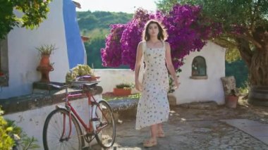 Akdeniz gezisinden hoşlanan kadın model gün ışığında yürüyor. Rüzgarlı beyaz elbiseli romantik bir kadın eski caddeleri keşfediyor. Sakin hassas bayan saçlarına dokunuyor yaz gününde yalnız