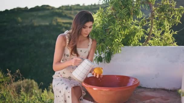Dama Tierna Sosteniendo Jarra Vertiendo Agua Sobre Frutas Terraza Mujer — Vídeos de Stock