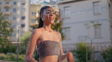 Heyecanlı bir kadın, Summer City 'de el sallıyor. Şehir merkezinde erkek arkadaşıyla buluşan neşeli kadın. Gülümseyen Afro-Amerikan modeli merhaba diyor. Şehre bakıyorum.
