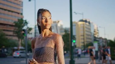 Koyu tenli bir kadın güneş ışığı şehrinde tek başına dolaşıyor. Afro örgü ören kadın trafik sıkışıklığı yolundan geçiyor. Moda model elinde akıllı telefonla yaz yürüyüşünün tadını çıkarıyor. Şık insanlar yaşam tarzı.