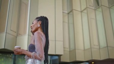 Modayı takip eden, cep telefonlu bir kız açık havada çay içiyor. Çekici rastalı kadın paket kahve içiyor ve şehir içinde yürüyor. Mutlu esmer, akıllı telefonları arıyor. Sakince karşıya geçiyor.