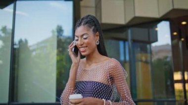 Neşeli, mutlu modacı şehir yürüyüşünde akıllı telefondan konuşuyor. Çekici Afrikalı Amerikalı kadın cep telefonuyla kahve ısmarlarken eğleniyor. Kasabada telefonla konuşan modaya uygun genç bayan.
