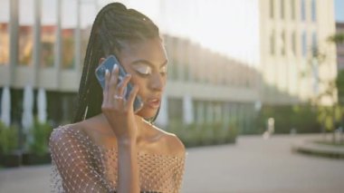 Hayalperest Afrikalı kadın Sunny Square 'de akıllı telefondan arıyor. Gümüş makyajcı kadın akşam meydanında cep telefonuyla konuşuyor. Dreadlocks modacısı güneş ışınları şehrinde cep telefonuyla eğleniyor.