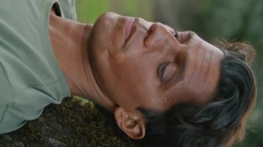 Akşam doğa portresi okurken yorgun bir adam. Sakin adam, Yosunlu Ağaç 'ın arkasında dikey olarak uzanan kitaptan zevk alıyor. Hasattan sonra kırsal alanda mola veren düşünceli erkek.