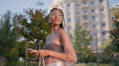 Moda Afrikalı bayan, Summer Caddesi 'nin kapanış noktasında bekliyor. Şehir merkezinde cep telefonu kontrol eden mutlu esmer kadın. Şehrin arka planında cep telefonu tutan neşeli, güler yüzlü bayan.