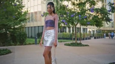 Moda kadını yazın sokağa adım atıyor. Güzel Afro-Amerikan kızı modern mahalle caddesine yakın poz vermeye gidiyor. Kendine güvenen esmer görünümlü bir fotoğraf makinesi. Aktif boş vakitlerin tadını çıkarıyor.