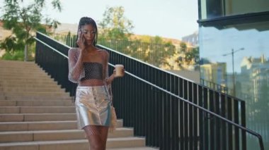 Modayı takip eden bayan merdivenlerde cep telefonuyla konuşuyor. Havalı rastalı kız turist yaz caddesinde elinde çayla telefon görüşmesi yapıyor. Rahat Afrikalı Amerikalı kadın iletişim için hücre kullanıyor.