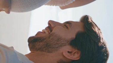 Müstakbel baba hamile karnını okşuyor. Güneşli deniz kıyısında dikey meleğin yanında oturuyor. Mutlu gülümseyen adam içinde doğmamış bir bebek varken sevgili göbeğini öpüyor. Genç bir aile çocuk bekliyor.