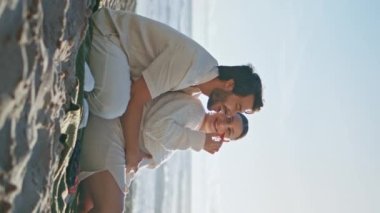 Müstakbel ebeveynler deniz kenarında dikey piknik yapıyorlar. Birlikte battaniyeye oturup kocasını besleyen hamile bir kadın. Mutlu, kaygısız bir çift bebek bekliyor sahilde sakin bir akşamın tadını çıkarıyorlar..