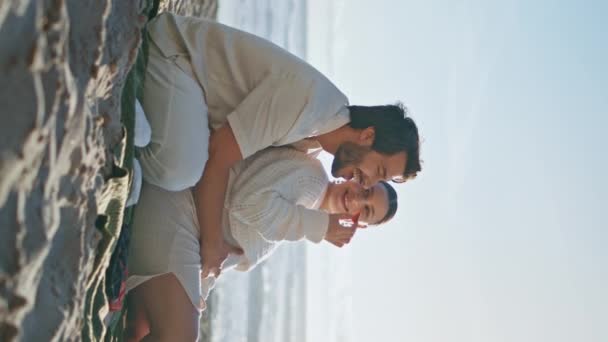 期待着父母们在风景如画的海滨垂直地带野餐 爱怀孕的妻子一起坐在毛毯上喂丈夫 快乐无忧无虑的夫妇期待着宝宝在海滩享受平静的夜晚 — 图库视频影像