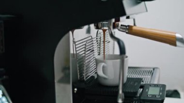 Modern elektrikli içecek makinesiyle nefis aromatik kahve hazırlama işlemi. Koyu renkli kafein sıvısı beyaz bardak döküyor. Profesyonel espresso cihazından taze demlenmiş kahve.