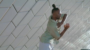 Moda dansçısı sokak dansını tek başına yapıyor. Hip-hop adamı açık havada dans gösterisi yapıyor. Afrikalı Amerikalı adam soyut mimaride ders veriyor. Sinema sanatı ilham kaynağı 