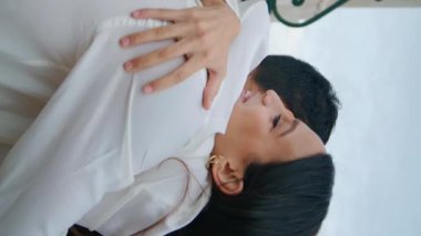 Romantik bir çift şehrin dikey görüntüsünü kucaklıyor. İki evli aşık düğün gününün tadını çıkarıyorlar. Gülümseyen Latin kadın kayıt bürosunun yanında kocasına sarılıyor. Birbirine bağlanan insanları sevmek