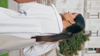 İş çifti şehir caddesinde dikey odaklı yakın çekimde geziniyor. Odaklanmış meslektaşlar yaz mevsiminde ofise giderken yeni başlatılan projeyi tartışıyorlar. Kadın erkek takımı merdivenlere geri dönüyor.