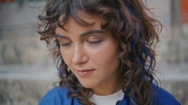 Sokakta kalem tutan düşünceli bir kızın portresi. Çekici, siyah saçlı, mesafeye bakan genç bir kadın başlangıçta düşünür. Kıvırcık öğrenci dışarıda ödev yapıyor..