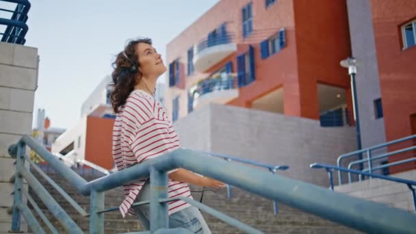 Kulaklıklı Mutlu Kadın Merdivenlerde Eğilmiş Müzik Dinliyor Neşeli Bir Meloman — Stok video