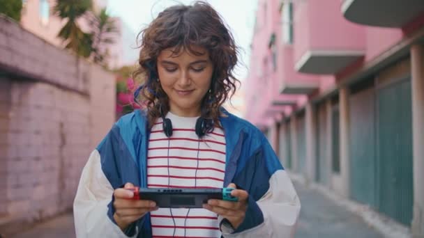 Tiener Spelen Handheld Console Met Glimlach Lopen Stedelijk Gebied Curly — Stockvideo