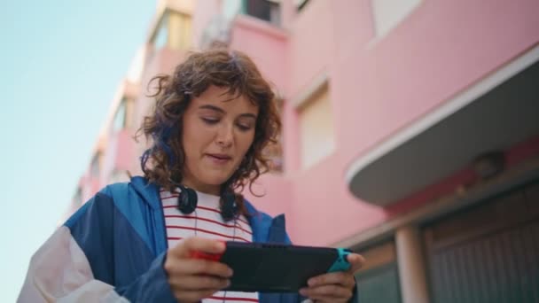 Şehir Caddesinde Tek Başına Gezen Taşınabilir Konsol Oynayan Bir Kız — Stok video