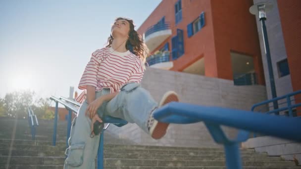 햇빛을 즐기는 귀걸이 계단에서 음악을 난간에 헤드폰에 편안한 거리에서 휴식을 — 비디오
