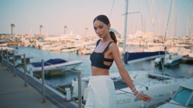 Rıhtımda demirli beyaz yatların önünde dinlenen mutlu kız. Hafta sonu lüks teknelerle dolgu yapan zarif bir kadın turist. Rıhtımda gülümseyen kameraya poz veren tasasız bir model..