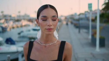 Güzel bir gezgin yaz tatiline çıkıyor. Yakın çekim. Muhteşem, rahat bir kadın lüks yatlarla rıhtımda geziniyor. Tasasız genç kız hafta sonu gezintisinin tadını çıkarıyor..