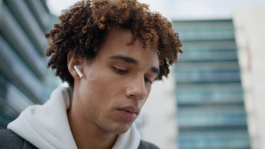 Kulaklık takan ciddi bir öğrenci açık hava portresi üzerinde çalışıyor. Kablosuz kulaklık takan kıvırcık saçlı adam binaların arka planında müzik dinliyor. Şehir merkezinde dizüstü bilgisayarı daktilo eden serbest çalışan biri.