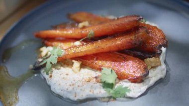Beyaz humus havucu tabağı yakın plan. Geleneksel Akdeniz mutfağı aperatifleri sebze ve yağ ile servis edilir. Çağdaş restoranın masasında duran eski seramik tabaktaki baharatlı yiyecekler. 