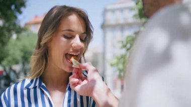 Romantik randevuda erkek, kadını elle besliyor. Doğa yakın plan. Tatmin olmuş kız arkadaş, yemeğin tadını çıkarıyor ve erkek arkadaşıyla iyi vakit geçiriyor. Meçhul bir koca yaz bahçesinde karısına dokunuyor.