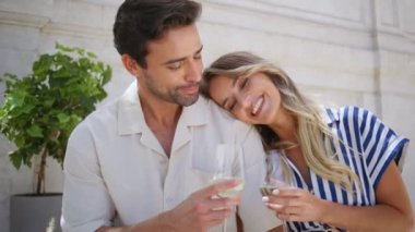 Mutlu yeni evliler romantik randevusu Sunshine Terasta yakın çekim. Yaz tatilinde şampanya içip gülen rahat aşıklar. Şarap kadehleri tutan neşeli bir çift. Karı koca alkol yıldönümünün tadını çıkarın. 