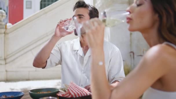 エレガントな配偶者は オープンスペースのレストランのクローズアップでワイングラスを楽しみます サンライトテラスでアルコール飲料を飲む金持ちハンサムな男 イタリアのマチョはガールフレンドと週末に白いケーブルを飛ぶ — ストック動画