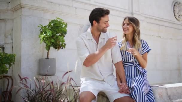 在浪漫的蜜月假期里 可爱的情侣们一起喝着白葡萄酒 快乐的恋人在夏日的喷泉前举杯庆祝结婚周年 爱情的概念 — 图库视频影像