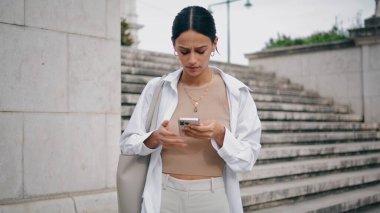 Merdivenlerde cep telefonu okuyan üzgün bir bayan. Sinirli iş kadını dışarıda şaşkın bir şekilde SMS yazıyor. Hayal kırıklığına uğramış bayan girişimci mesajlaşması caddede yalnız başına bekliyor.