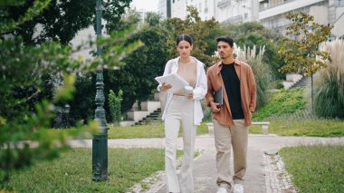 Üniversite öğrencileri kampüste zum yapıyor. Arkadaş canlısı ekip dersten sonra haberleri paylaşıyor. Rahatlamış arkadaşlar dinlenme parkı içiyorlar. Yakından. Gençler öğle arasında konuşuyor.